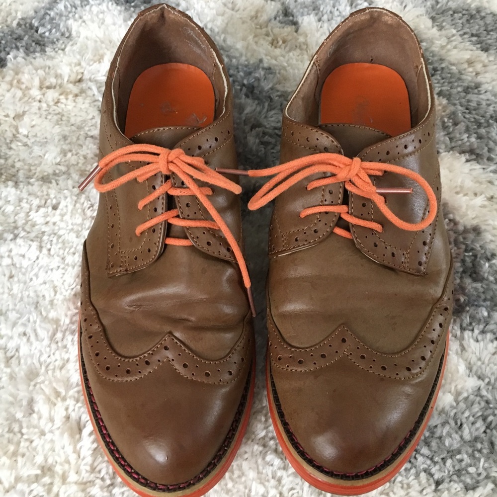Brown oxfords with orange sole and laces.